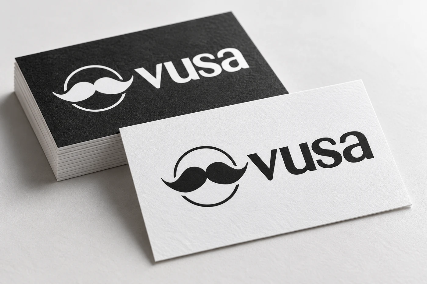 Zbliżenie wizytówek VUSA z nadrukiem logo i widoczną fakturą papieru